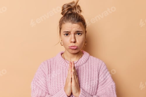 Preview: Please Help Me. Upset Young Woman With Combed Hair Purses Lis Looks Sadly At Camera Keeps Palms