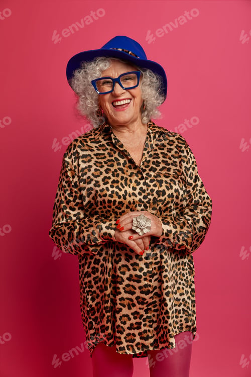 Preview: Studio Shot Of Aged Charming Lady Dressed In Fashionable Outfit, Has Beaming Smile, Looks At Camera