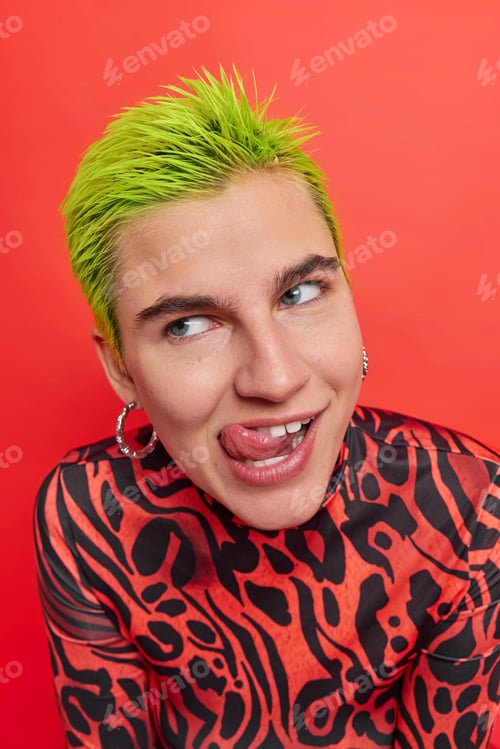 Preview: Dreamy Stylish Female Rock Fan Licks Lips With Tongue Looks At Something Delicious Or Pleasant