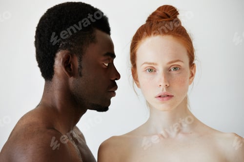 Preview: Coffee And Milk. Portrait Of Young Mixed Race Couple Posing Naked Against White Studio Wall