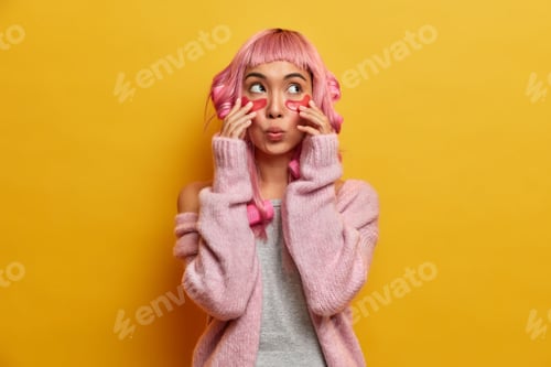 Preview: Beauty Woman Touches Patches, Looks Wondered Above, Has Surprised Expression, Wears Hair Curlers