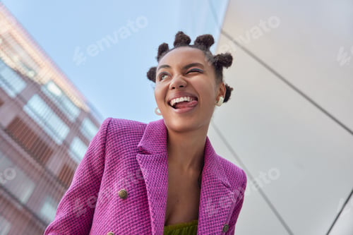 Preview: Underside View Of Cheerful Stylish Woman Winks Eye Sticks Out Tongue Has Fun While Walking In Urban