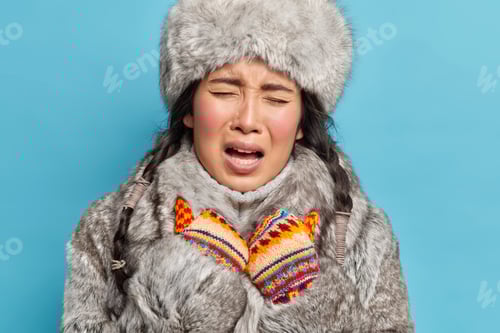 Preview: Close Up Shot Of Displeased Young Asian Inuit Woman Wears Knitted Mittens And Winter Outfit Feels