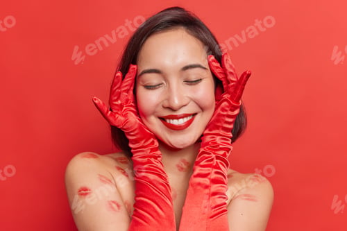Preview: Headshot Of Positive Asian Woman Touches Face Gently Has Healthy Skin Wears Red Lipstick Keeps Eyes