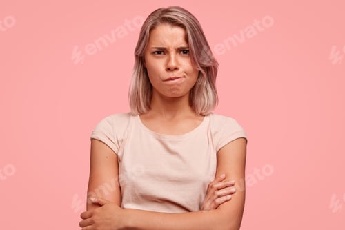 Preview: Angry Furious Female Keeps Hands Crossed And Curves Lips, Being Dissatisfied With Something, Wears