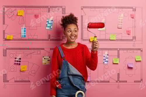 Preview: Glad Smiling Afro American Decorator Holds Paint Roller, Busy Doing Repairing According To Design