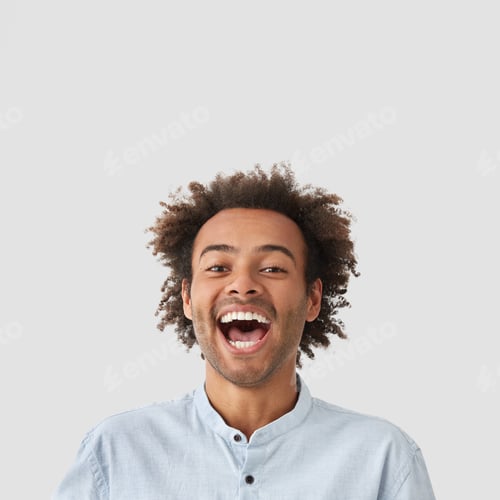 Preview: Funny Joyful Mixed Race Male Laughs Happily At Good Joke, Opens Mouth And Shows White Teeth, Has