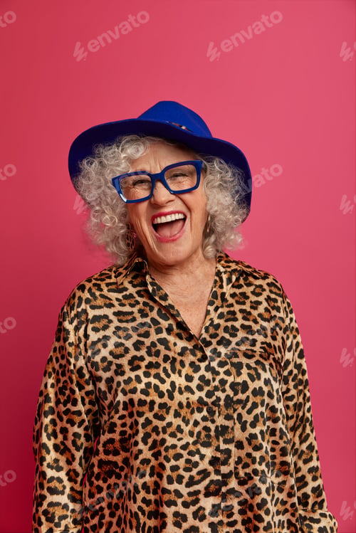 Preview: Fashionable Curly Haired Elderly Woman Wears Trendy Blue Hat, Transparent Glasses And Leoprad