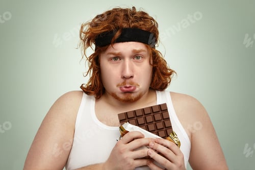 Preview: Unhappy Obese Redhead Man Wearing Black Sports Headband And White Tank Top Having Sad And