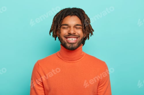 Preview: Carefree Smiling Dark Skinned Millennial Guy Has Happy Facial Expression, Laughs At Something