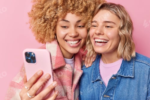 Preview: Happy Beautiful Women Take Selfie Via Smartphone Smile Broadly Show White Teeth Have Fun Wears