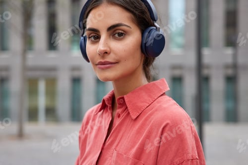 Preview: Horizontal Shot Of Good Looking Brunette Woman Looks Directly At Camera With Serious Expression