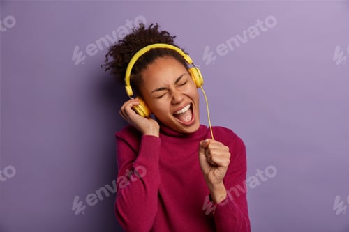 Preview: Music And Entertainment Concept. Cheerful Millennial Afro American Girl Sings Song, Keeps Mouth