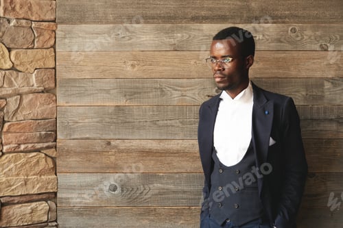 Preview: Graceful African American Gentleman Standing Indoors In Daylight On Wooden Background And Looking