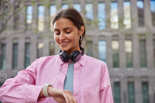 Preview: Beautiful Brunette Woman Looks At Wristwatch Checks Time Waits For Friend Wears Pink Shirt And