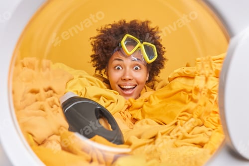 Vista previa: Positive Young Afro American Woman Does Laundering At Home Smliles Broadly Has Fun Wears Snorkeling