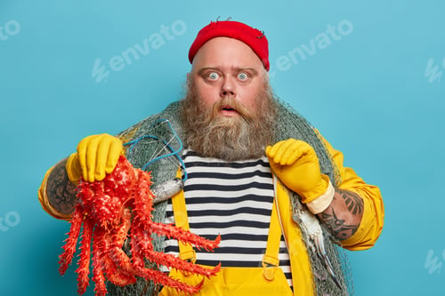 Preview: Horizontal Shot Of Stunned Experienced Boatswain Or Fisherman Holds Big Octopus, Didnt Expect To