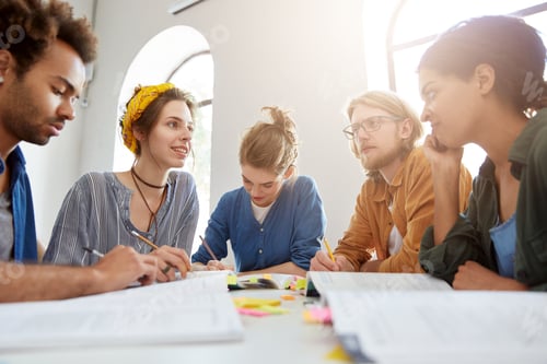 Preview: Young College Students From Different Countries Working Together Sitting At Coworking Space At
