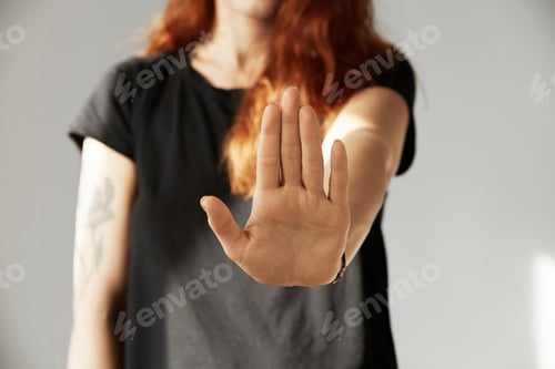 Preview: Cropped Isolated View Of Young Woman With Red Hair Making Stop Gesture With Her Palm. Portrait Of