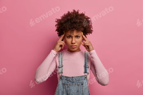Preview: Young Beautiful Tired Woman Suffers Migraine Or Headache, Touches Temples And Looks Intense, Asks