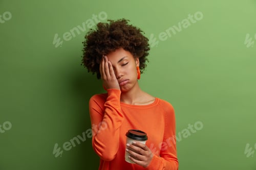 Preview: Sleepy Exhausted Dark Skinned Curly Woman Holds Cup Of Coffee, Cannot Wake Up And Go To Work, Had