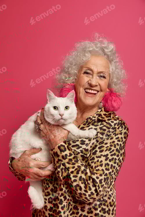 Preview: Indoor Shot Of Happy Wrinkled Granny Petting Her White Cute Cat, Being Old Friends, Dressed In