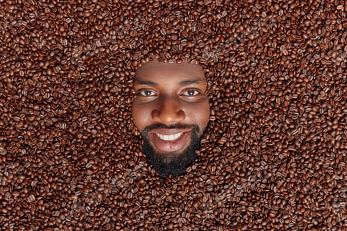 Preview: Cheerful Dark Skinned Guy Drowned In Aromatic Roasted Coffee Beans Going To Brew Caffeine Beverage