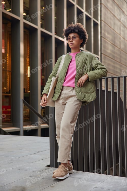 Preview: Urban Lifestyle. Beautiful Fashionable Young Ethnic Woman With Curly Hair Focused Forward With