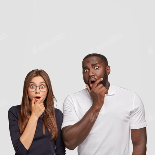 Preview: Studio Shot Of Astonished Mixed Race Partners Stare With Eyes Full Of Disbelief, Open Mouthes, Cant