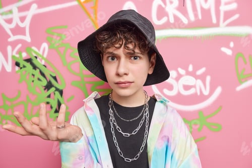 Preview: Cool Looking Indignant Youngster Shrugs Shoulders And Looks Clueless At Camera Dressed In