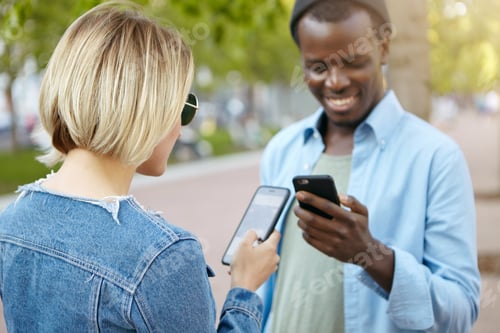 Preview: Stylish Blonde Female In Denim Jacket And Sunglasses Meeting Her African Male Friend On Street