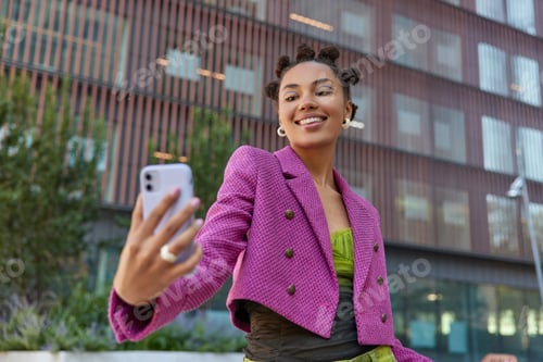 Preview: Joyful Pretty Millennial Girl With Hair Buns Looks Positively At Smartphone Camera Speaks On Video
