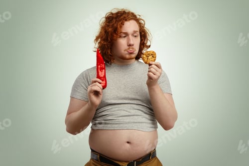 Preview: People, Food, Diet, Nutrition And Unhealthy Lifestyle. Studio Shot Of Sad Indecisive Young Plump