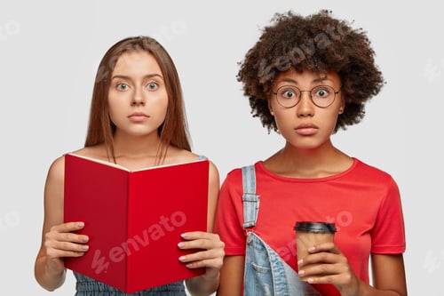 Preview: Back To School Concept. Surprised Mixed Race Schoolgirls Stand Next To Each Other, Hear Something
