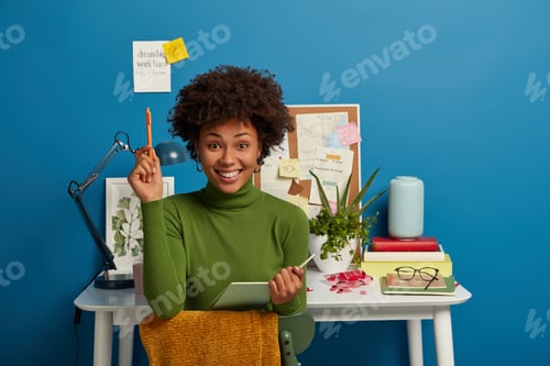 Preview: Pretty Curly Young Woman Writes Notes Or Summary, Holds Notepad And Pen, Prepares For Test, Session