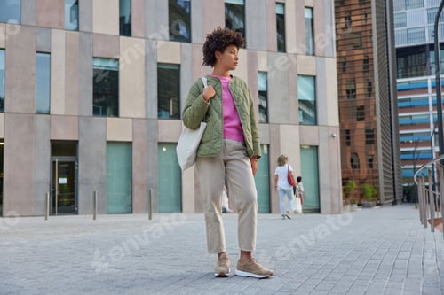 Preview: Full Length Shot Of Pensive Young American Woman Dressed In Stylish Clothes Carries Bag Looks Away