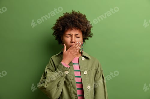 Preview: Sleepy Exhausted African American Woman Covers Mouth With Palm, Needs Sleep, Wakes Up Early In