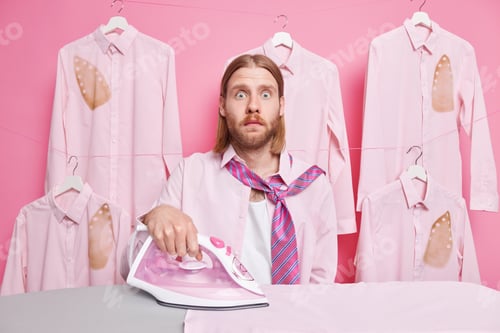 Preview: Shocked Redhead Man Strokes Clothes Uses Electric Stream Iron Wears Shirt And Tie Around Neck Has