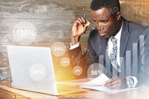 Preview: Serious African Businessman Looking At Laptop Screen, Studying A Financial Report, Doing Paperwork