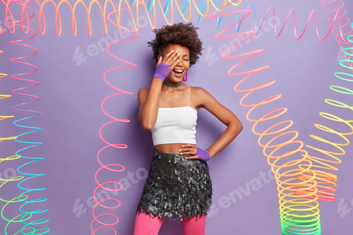 Preview: Stylish Carefree Woman Makes Face Palm, Wears Cropped Top And Glittering Skirt, Laughs Happily, Has