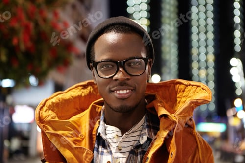 Preview: Close Up Portrait Of Cheerful And Happy Young Dark-Skinned Male Tourist Wearing Winter Coat