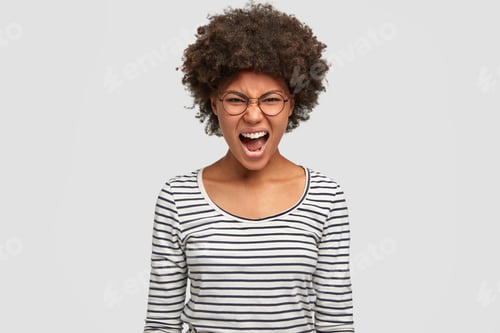 Preview: Aggressive Dark Skinned Young Female In Ire, Expresses Great Rage, Shouts With Annoyance, Frowns