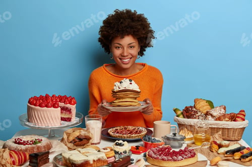 Preview: Indoor Shot Of Curly Woman Has Sweet Bakery Lunchtime, Holds Plate With Delicious Sugary Creamy