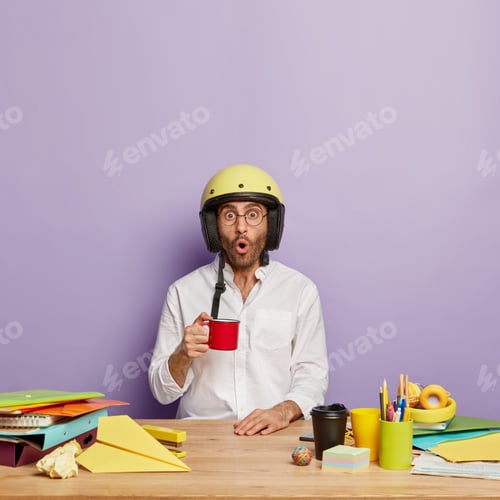 Preview: Young Male Specialist Drinks Tea From Red Cup, Dressed In Formal Shirt, Helmet On Head, Has Shocked