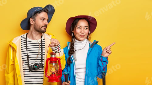Preview: Shot Of Mixed Race Woman And Man Carry Gas Lamp, Wear Hat And Casual Clothes, Have Trip In Nature