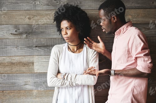Preview: Young Displeased Black Male Gesturing In Indignation, Arguing With His Stylish Girlfriend, Who Is