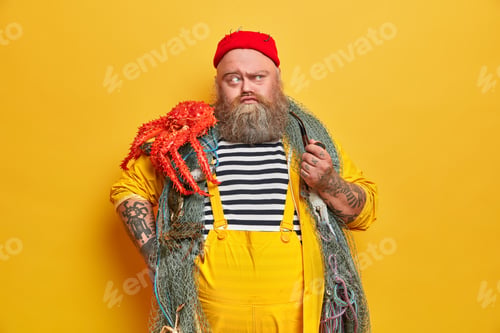 Preview: Serious Thoughtful Fisherman With Thick Beard, Caught Big Octopus And Smokes Pipe Indoor. Old