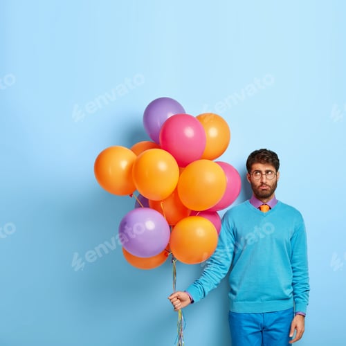 Preview: Displeased Balloon Artist Stands With Party Accessories, Has Sad Expression, Tired After Decoration