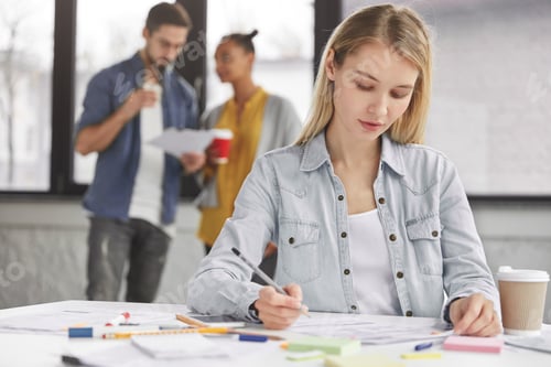 Preview: Smart Blonde Pretty Female Student Wears Denim Jacket, Writes Down Something In Papers, Prepares