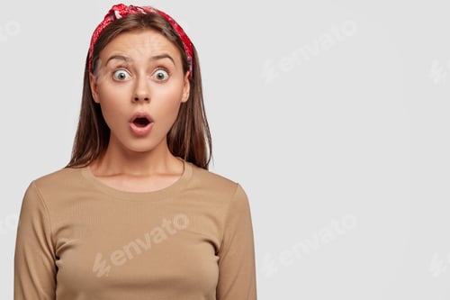 Preview: Stupefied Youngster With Bugged Eyes, Widely Opened Mouth, Dressed In Beige Sweater And Headband